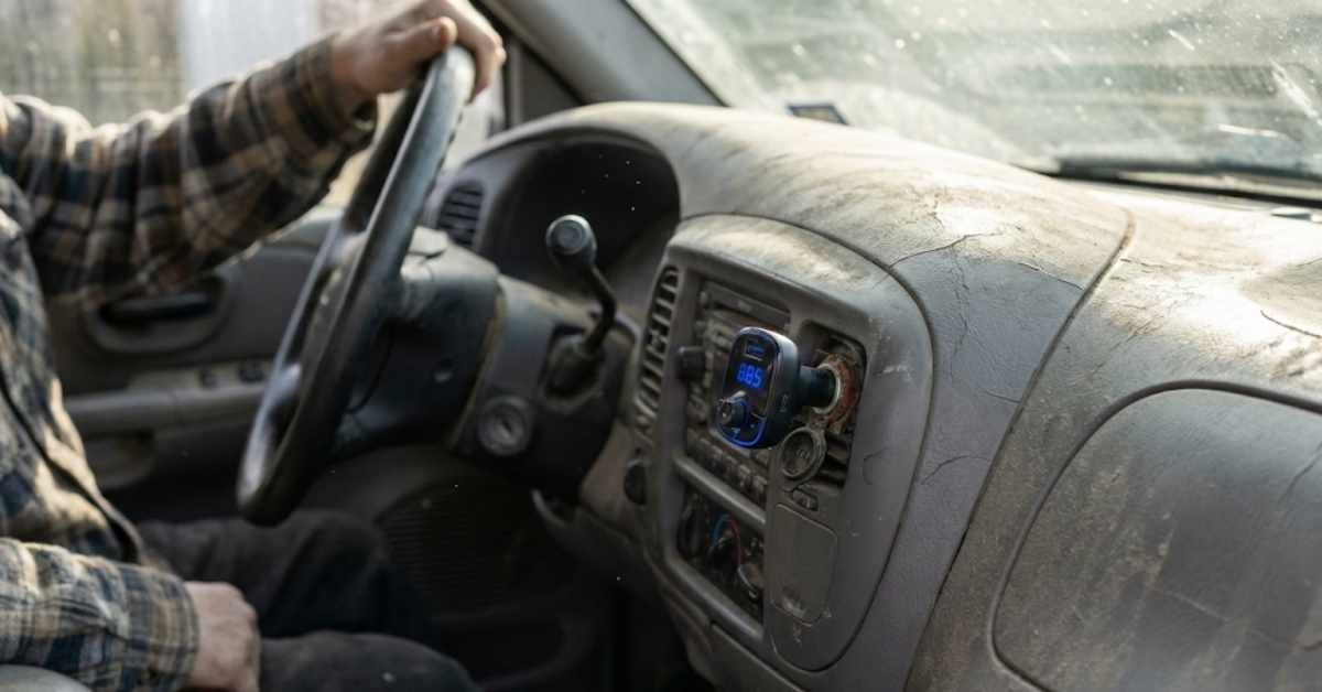 Bluetooth FM transmitter plugged into an old car dashboard cigarette lighter.