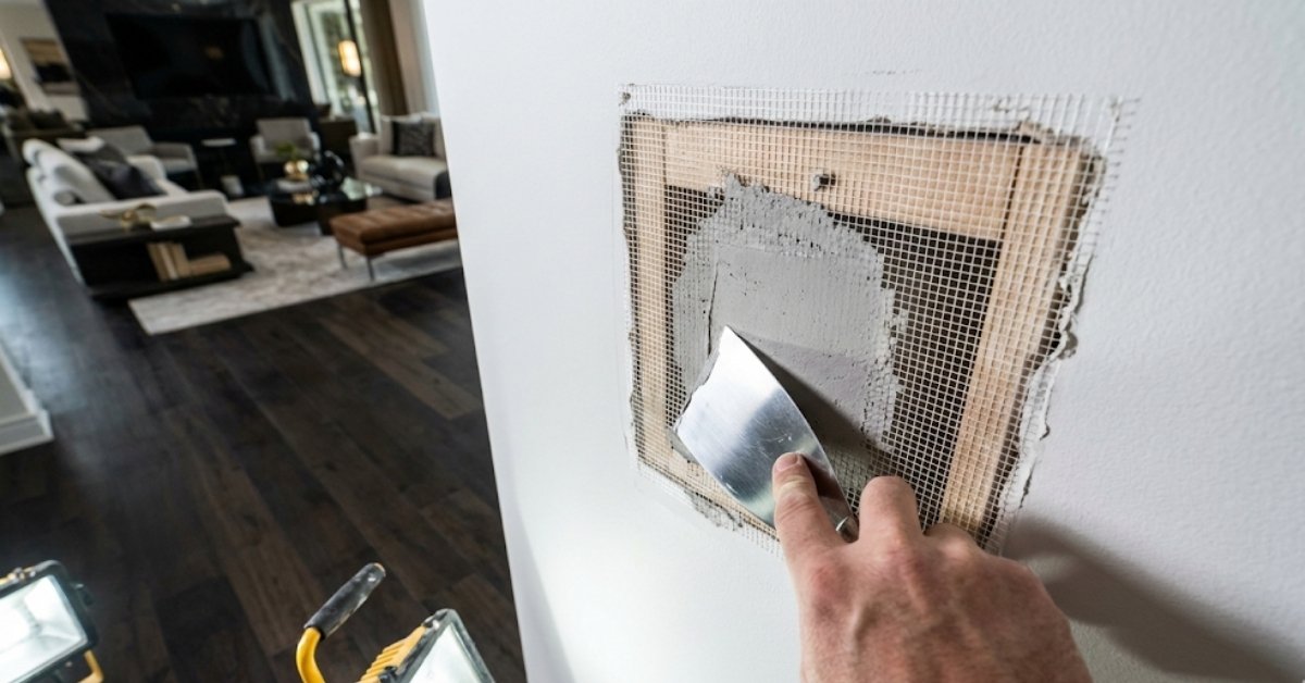 A professional-grade repair of a large hole in a drywall wall using wooden backers and mesh tape.