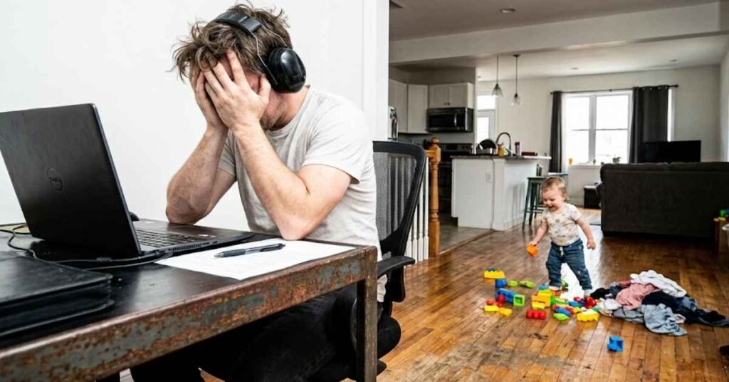 A Master Contractor Explains Why Open Floor Plans Are Officially Dead in 2026 Designs 3 A remote worker wearing headphones in a loud open floor plan living room.