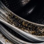 Dirty washing machine detergent drawer with mold and slime.